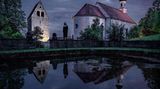 Eine Nonne steht bei Nacht vor einem Kloster