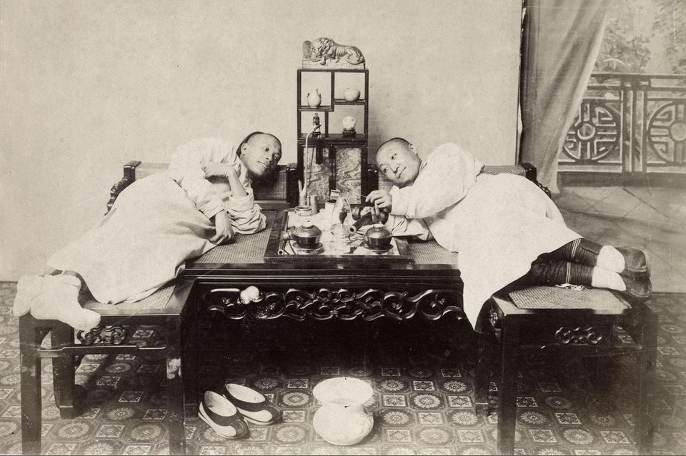 Zwei Männer rauchen Opium im China des 19. Jahrhunderts. Von Asien aus verbreitete sich der Brauch nach Europa und Amerika. Das Rauchen diente der Entspannung und unterdrückte in Zeiten von Nahrungsknappheit den Hunger