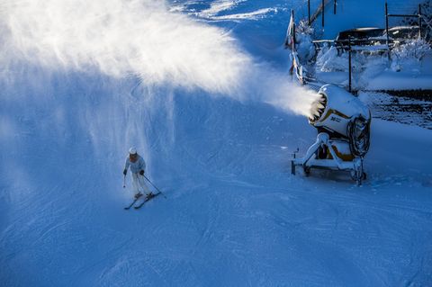 Ein Skifahrer unter einer Schneekanone im Mittelgebirge
