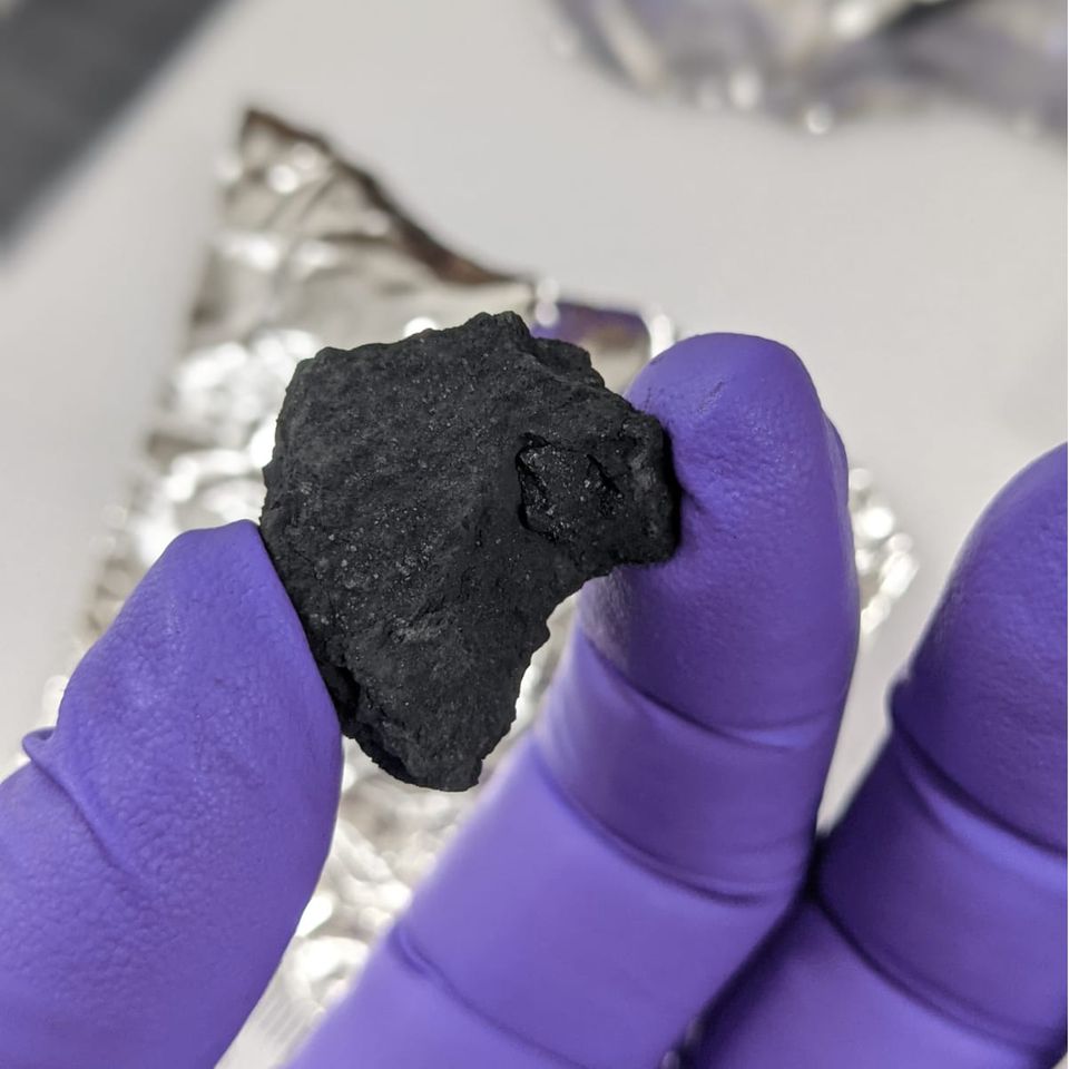 Forschender hält Meteorit in der Hand