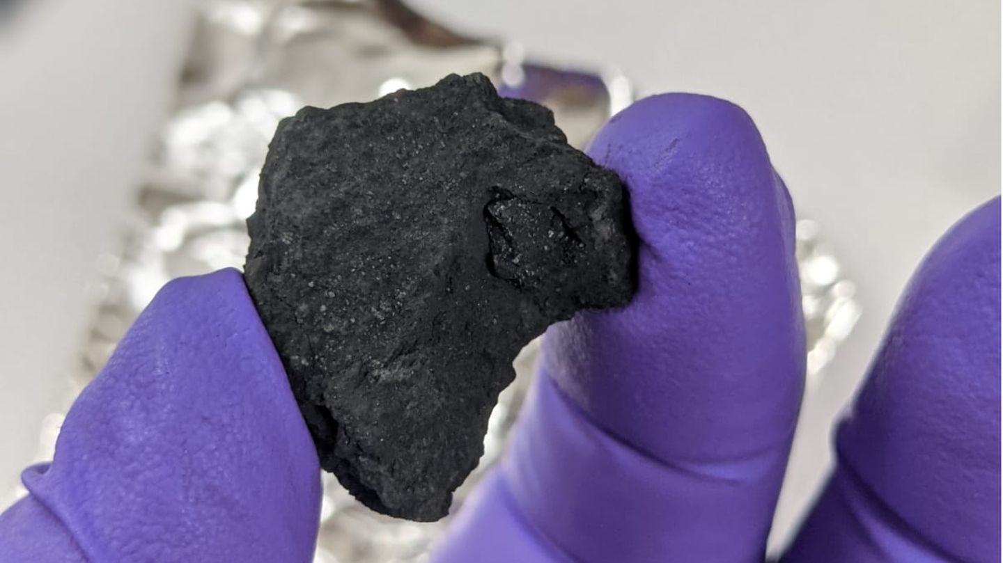 Forschender hält Meteorit in der Hand