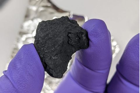 Forschender hält Meteorit in der Hand