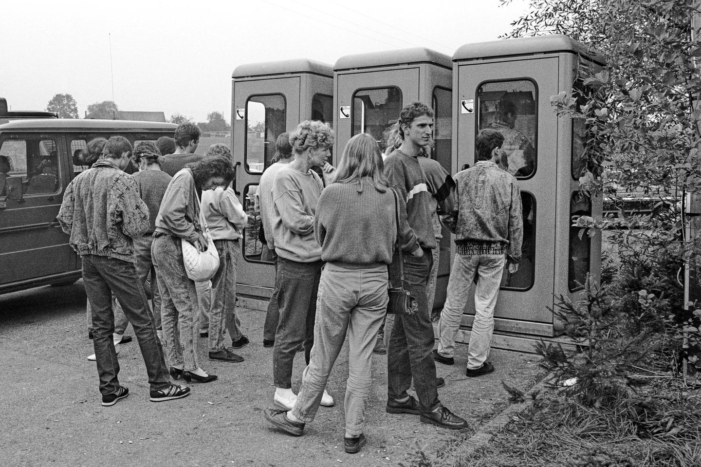 Wartende Menschen vor Telefonzellen