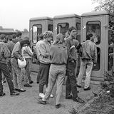 Wartende Menschen vor Telefonzellen