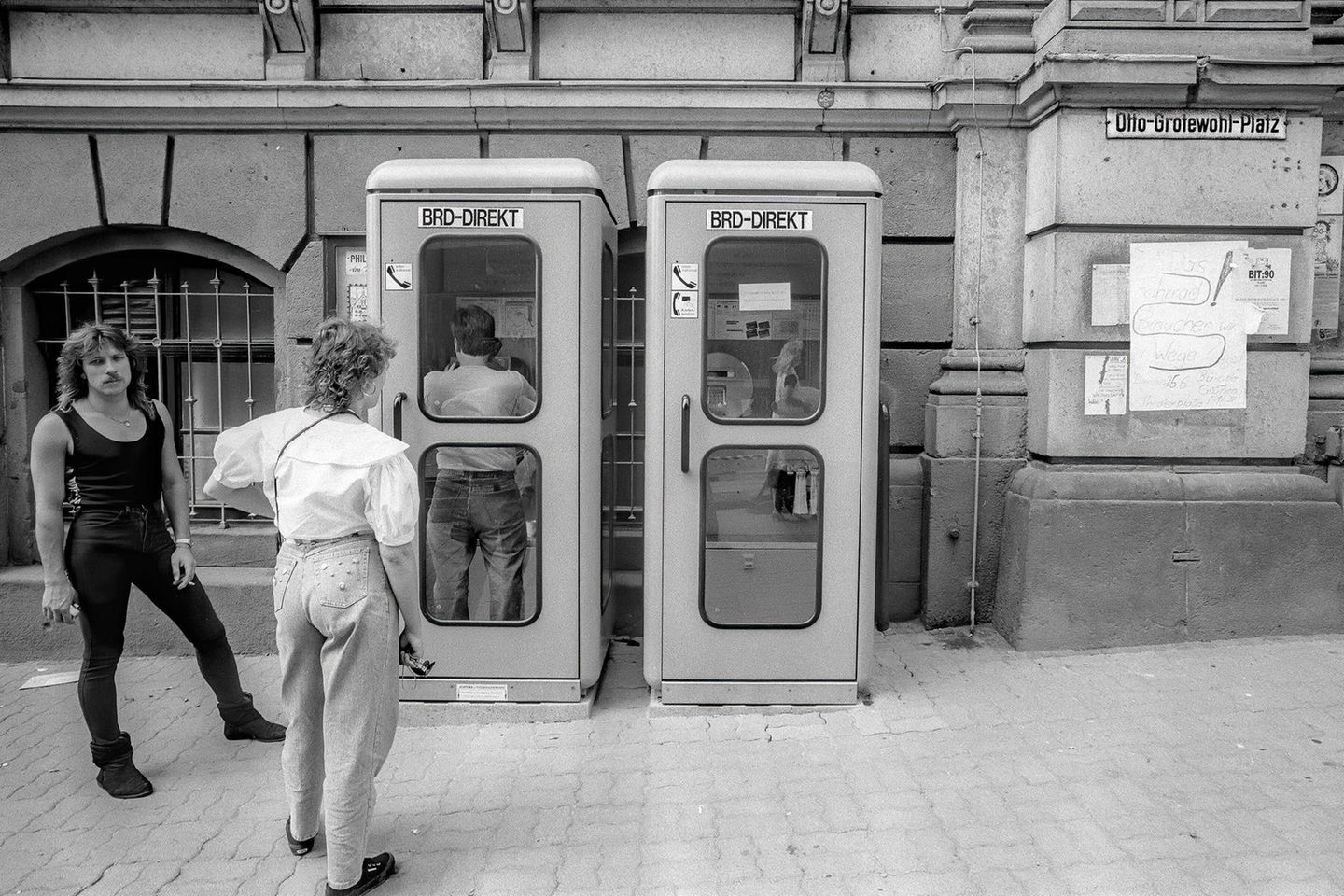 Männer vor mehreren Telefonzellen