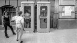 Männer vor mehreren Telefonzellen