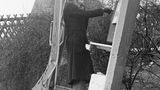 Frau telefoniert in demolierter Telefonzelle, 1973