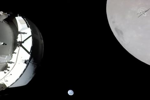 Eine Kamera an Bord der "Orion"-Kapsel zeigt das Raumschiff (l) im Weltraum, den Mond (r) und klein im Hintergrund die Erde. Fot