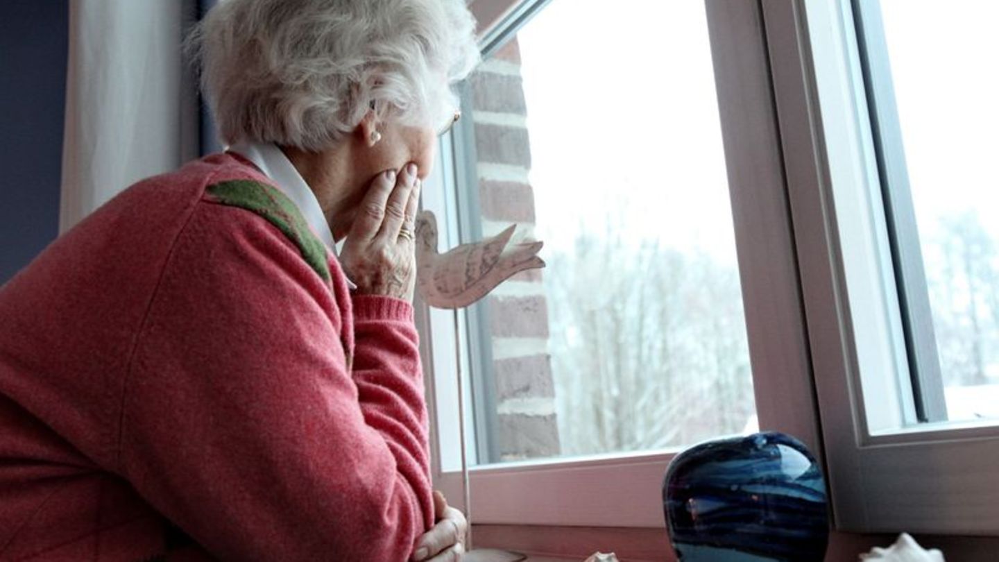 Alte Frau schaut aus dem Fenster