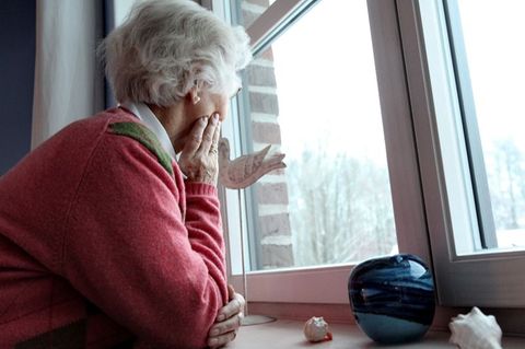 Alte Frau schaut aus dem Fenster