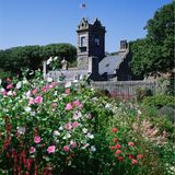 Blick über ein Blumenbeet auf ein Herrenhaus