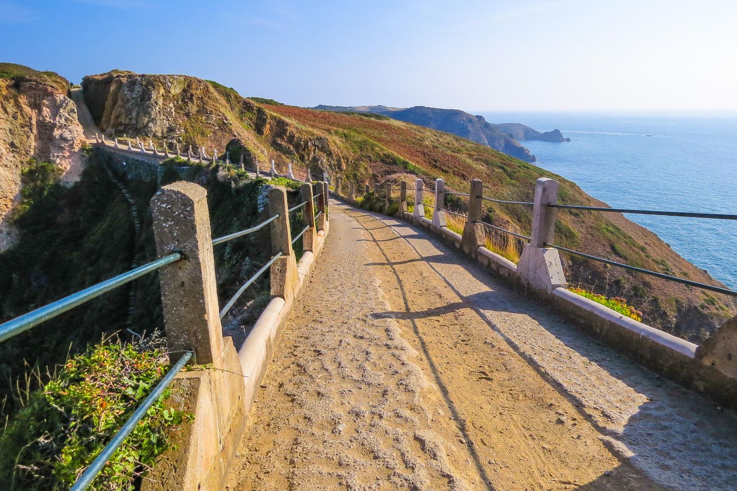 Sturmfestigkeit gefragt Sandiger Weg über Berge, auf der rechten Seite ist das Meer