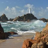 Ein Leuchtturm auf einem Felsen, der von Wasser umringt ist