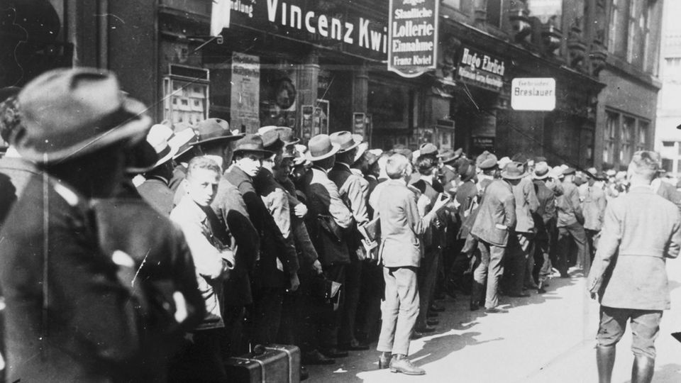 1923 stürzt die Hyperinflation Millionen Menschen in die Armut, hier: lange Warteschlangen vor der Reichsbank in Berlin