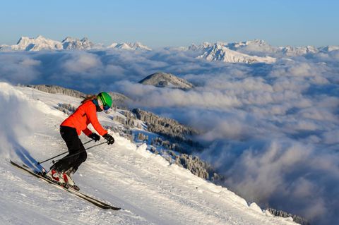 Eine Frau fährt auf Skiern einen Berg hinunter