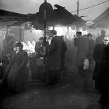 Schwarz-weiß-Foto von Passanten, die im Smog auf einem Markt einkaufen