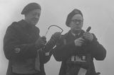 Schwarz-weiß-Foto von zwei Männern, die die Luftverschmutzung messen