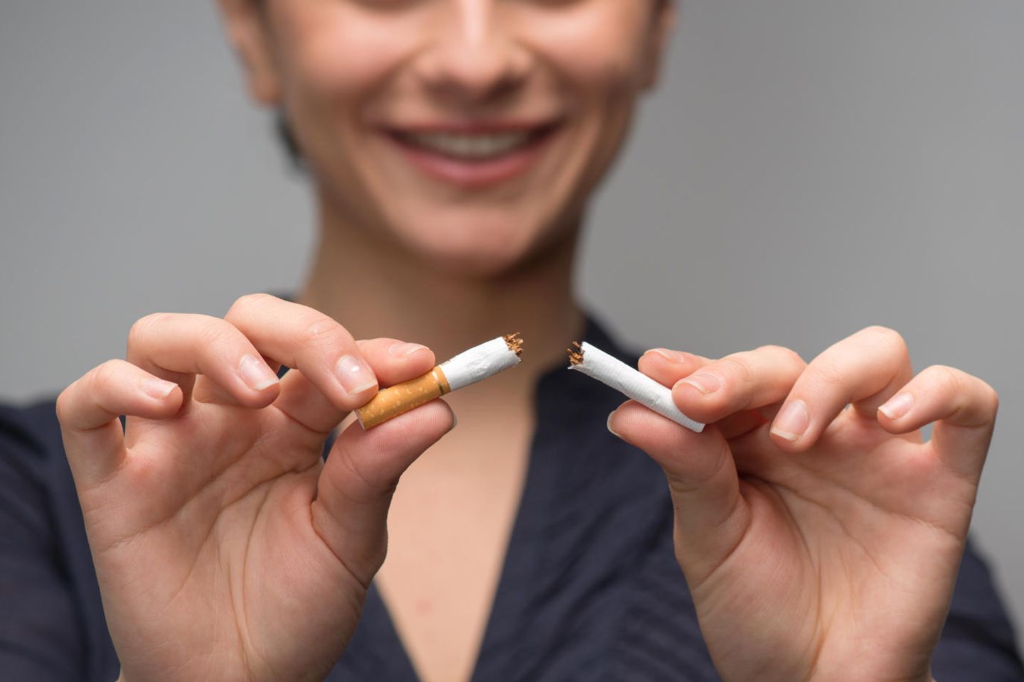 Mit dem Rauchen aufhören: Frau zerbricht eine Zigarette