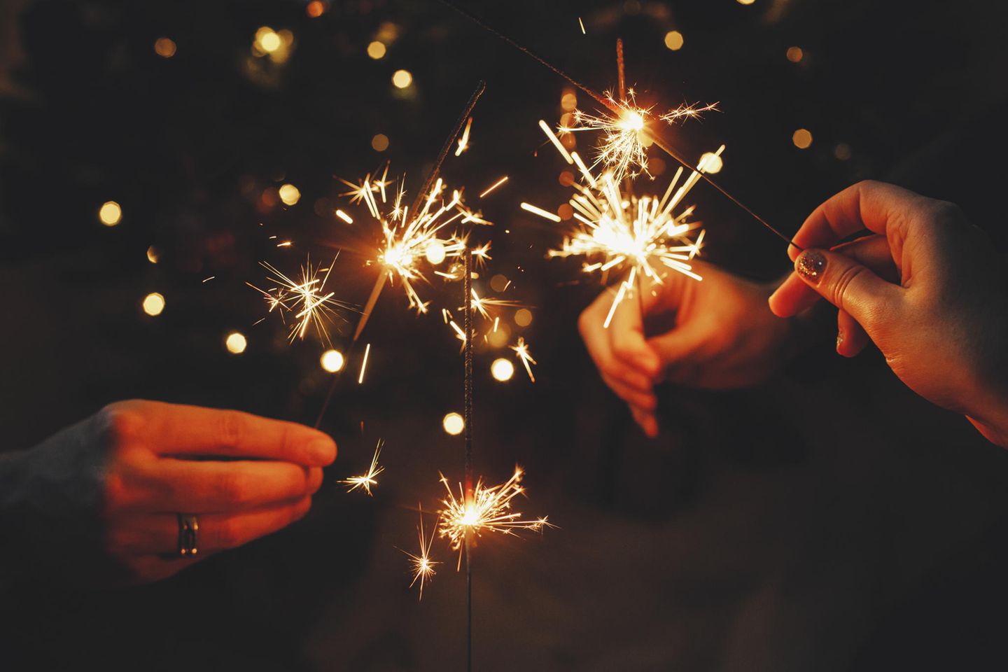 An Silvester auf Feuerwerk verzichten Hände mit Wunderkerzen