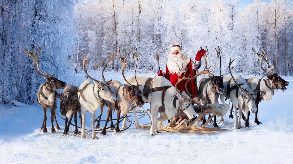 Ein Weihnachtsmann mit seinem Schlitten, der von einer Gruppe Rentieren gezogen wird Ein Weihnachtsmann mit seinem Schlitten, der von einer Gruppe Rentieren gezogen wird