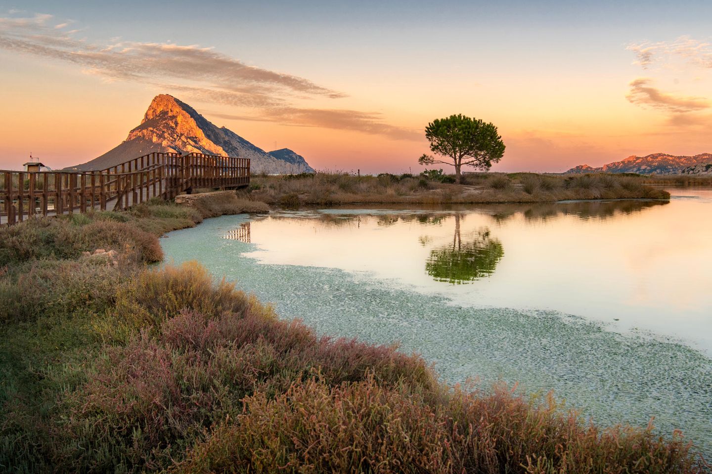 Lagune im Vordergrund, im Hintergrund ein höherer Berg, der von Abendlicht angestrahlt wird