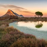 Lagune im Vordergrund, im Hintergrund ein höherer Berg, der von Abendlicht angestrahlt wird