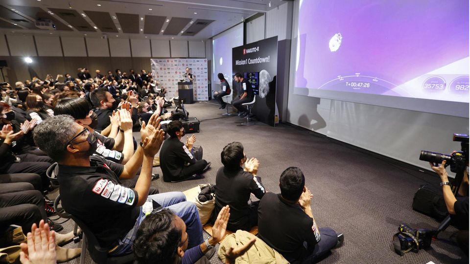 Menschen beklatschen in Tokio den Start einer Falcon 9-Rakete des US-Raumfahrtunternehmens SpaceX