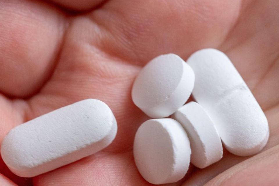 Weiße Tabletten in der Hand