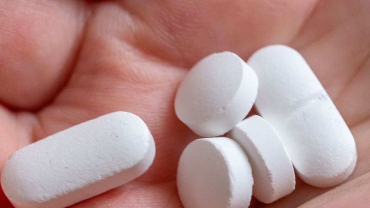 Weiße Tabletten in der Hand