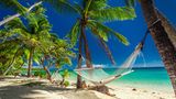 Weißer Sandstrand mit Palmen und Hängematte