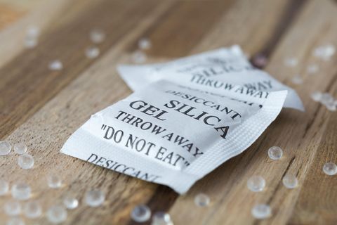 Silica-Gel-Tütchen liegt auf einem Holztisch
