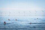 Kopenhagen, Dänemark:  Vor der Kulisse des Middelgrunden Offshore Windparks baden Menschen am Amager Strand. Mit Windkraft werden in dem skandinavischen Land mehr als 14 Prozent des Stroms produziert