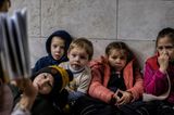 "I once had a home", hat der us-amerikanische Fotograf Ron Haviv seine Reportage aus der in einen Verteidigungskrieg gezwungenen Ukraine genannt. Es sind Bilder von Abschied und Flucht, von verlassenen Kinderwagen, von zerstörten Brücken und zerschossenen Wohngebäuden. Und von Kellern und Metrostationen, in denen Kinder geboren werden. In denen sie spielen. Und in denen sie lernen.  Eine Lehrerin liest einer Gruppe von Mädchen und Jungen in einem Souterrain der Hauptstadt Kiew Geschichten vor. Vielleicht ist es ein spannendes Märchen, das sich in den Augen der Kinder spiegelt. Aber ebenso könnten es all die von der Erfahrungen der Kinder ausgelösten Emotionen sein, die sich hier zeigen: von Angst bis Erschrecken bis Fassungslosigkeit.  Millionen Ukrainerinnen mit ihren Kindern sind auch innerhalb des Landes auf der Flucht. Fast 1000 Schulen waren, Stand November 2022, beschädigt, fast 130 komplett zerstört – mindestens 400 Kinder hatten durch Artilleriebeschuss ihr Leben verloren, 800 ihre körperliche Unversehrtheit. Das Recht auf Leben, Artikel 6 der UN-Kinderrechtskonvention, das Recht auf Spiel und Freizeit (Art. 31), das Recht auf Bildung (Art. 28) – für Mädchen und Jungen in der Ukraine ist dies seit Kriegsbeginn im Februar 2022 bei jedem Alarm allenfalls im Untergrund ein wenig gesichert.  Havivs Fotografie wurde mit dem zweiten Preis des "Unicef-Foto des Jahres"-Preises geehrt.