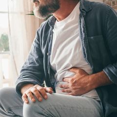 Mann möchte seinen Magen beruhigen