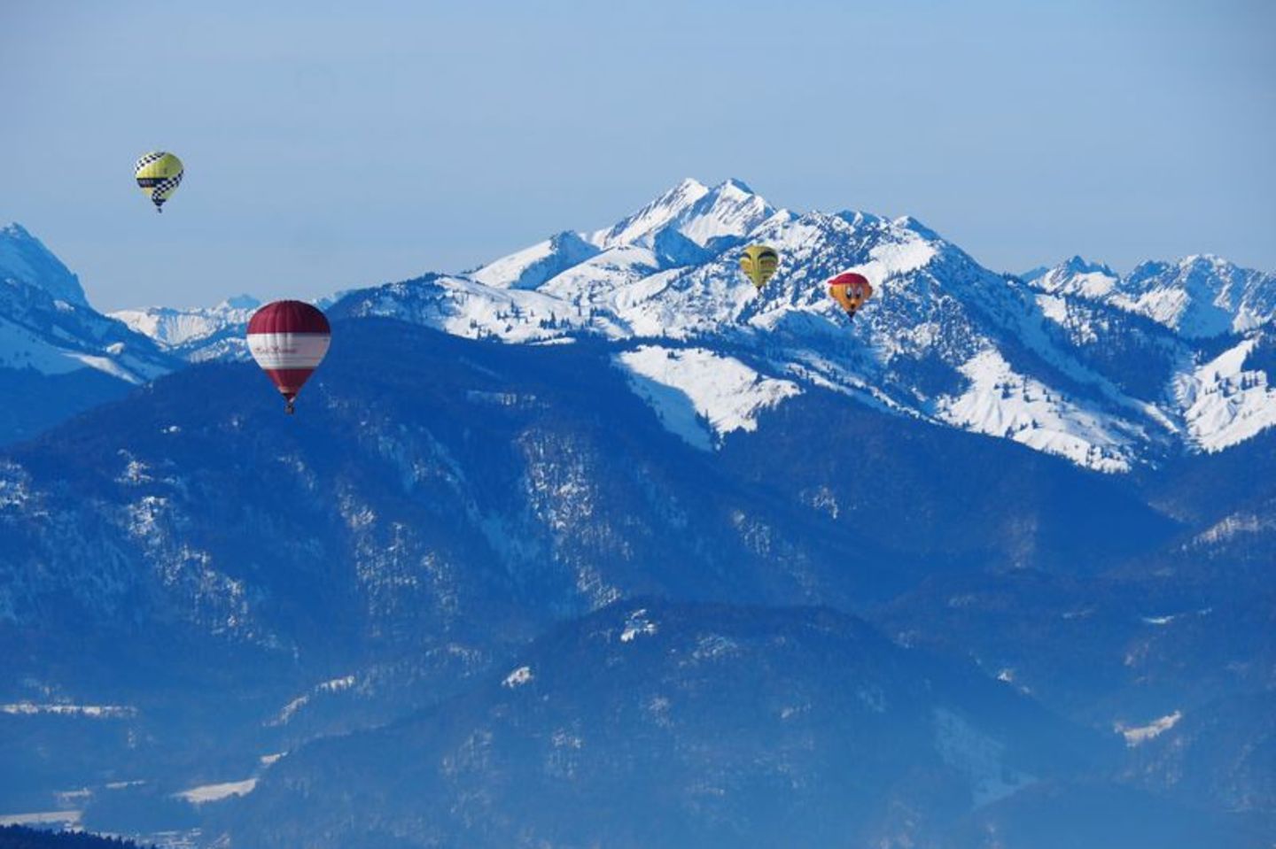 Aussicht auf die Berggipfel und andere Heißluftballons aus dem Ballonkorb.