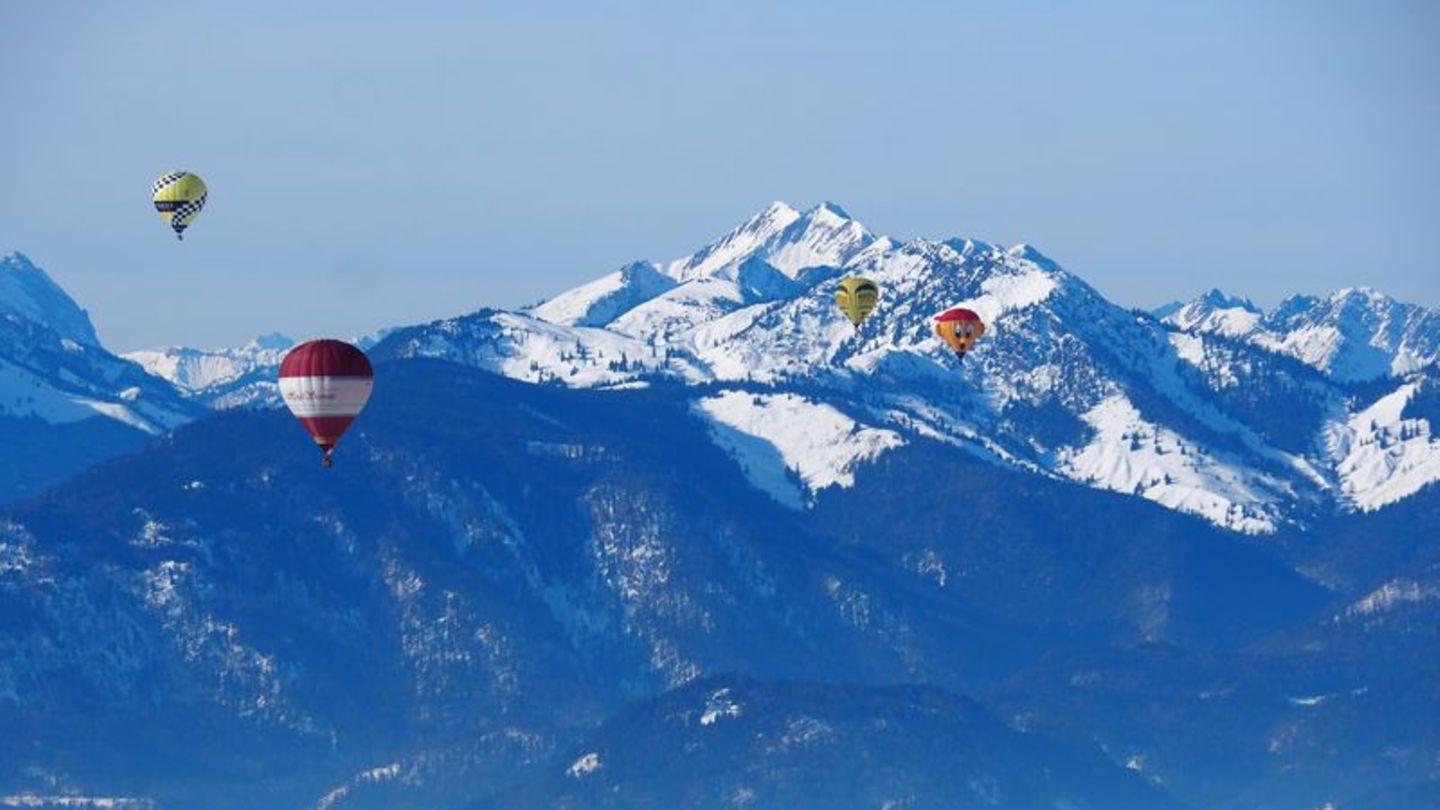 Aussicht auf die Berggipfel und andere Heißluftballons aus dem Ballonkorb.