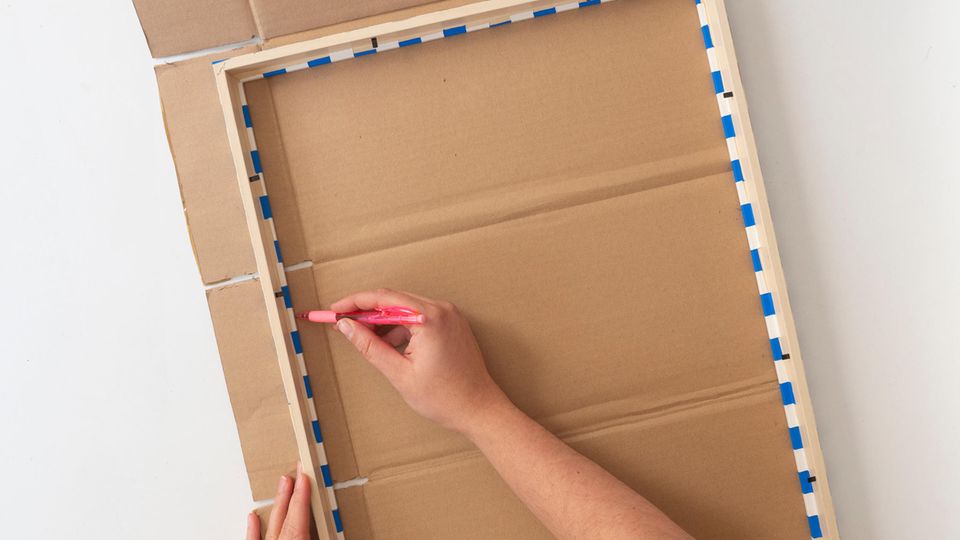 Pinnwand selber machen - Die Innenkante eines Bilderrahmens wird auf einem Stück Pappe nachgezeichnet