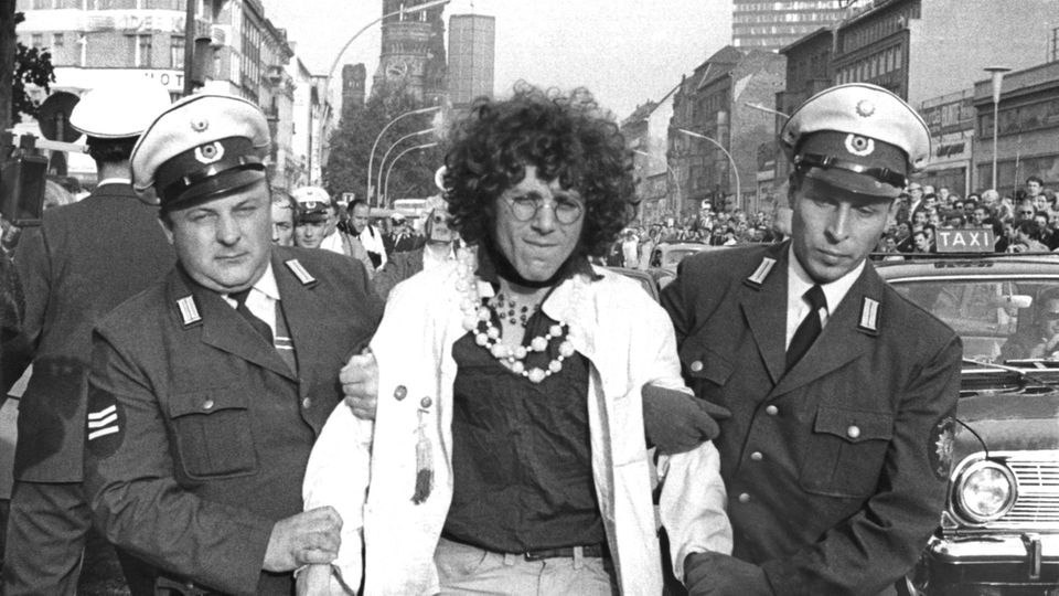 Der Kommunarde Rainer Langhans wird nach seiner Festnahme von zwei Polizeibeamten abgeführt