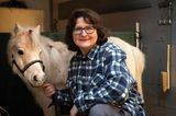 Auf der linken Seite ist ein helles Pony, auf der rechten Seite eine Frau