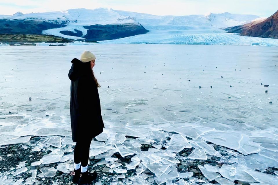 Samira Debbeler steht im Eis und blickt auf eine Gletscherzunge