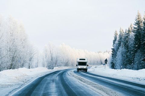 Wohnmobil unterwegs in verschneiter Landschaft