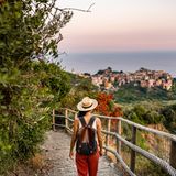Frau wandert an der Küste der Cinque Terre in Richtung Corniglia