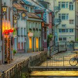 Beleuchtete Gasse mit bunten Häuschen an einem Bach in Freiburg