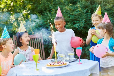 Kinder feiern Geburtstag mit Luftballons und Partyhüten