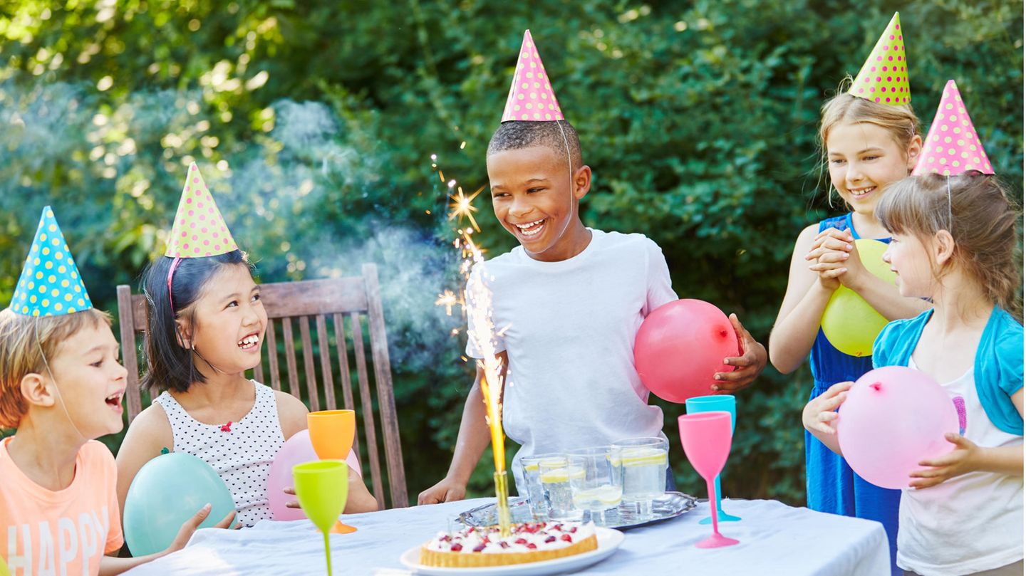 Kinder feiern Geburtstag mit Luftballons und Partyhüten
