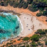 Malerisch schmiegt sich der gerade einmal 80 Meter breite Sandstrand in die Bucht von Cala Varques. Hotels, Cafés oder Geschäfte sucht man hier vergebens. Stattdessen umgibt dichter Wald den feinen Sandstrand bei Porto Cristo, den man nur zu Fuß erreichen kann. Am besten parkt man auf dem Parkplatz an der Hauptstraße Ma-4014 und nimmt von dort den letzten Teil des Weges auf sich. Familien schätzen den flach abfallenden Sand in der Bucht, Kletterer besuchen sie wegen der zerklüfteten Felswände und FKK-Freunde finden in einer weiteren kleinen Bucht ihren Platz, die ein Küstenwanderweg mit der Cala Varques verbindet