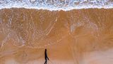 3rd Place - Russell Charters - Australia  Walking the dog along the beach. Photo taken by DJI Mavic Air2 drone of my partner walking our dog, Luna. ( Focal length 24mm, F/2.8, 1/100 sec, ISO1000.)