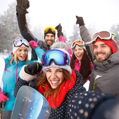 Frauen und Männer im Schnee mit Skibrillen auf dem Kopf