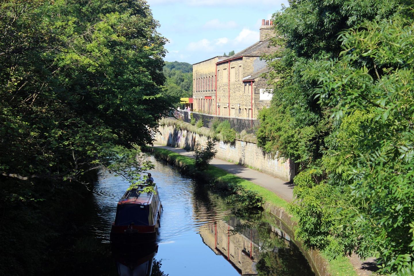 Über 200 Kilometer erstreckt sich der Leeds and Liverpool Canal. Gebaut ab dem 18. Jahrhundert, diente der Kanal meist dem Kohlentransport. Heute werden die 91 Schleusen vor allem von privaten Hausbooten genutzt, während sich auf den alten Treidelwegen Spaziergänger und Fahrradfahrerinnen erholen. Immer wieder wechseln sich kleine Städte und Naturlandschaften ab, gesprenkelt von ehemaligen Industrieorten wie Saltaire, das weltbekannt wurde für seine innovative Städteplanung