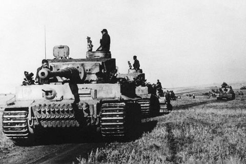 Schwarz-weiß-Foto, auf dem ein Kampfpanzer im Zweiten Weltkrieg über ein Feld rollt